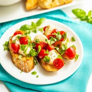 Baguette slices with tomatoes and mozzarella and basil on top