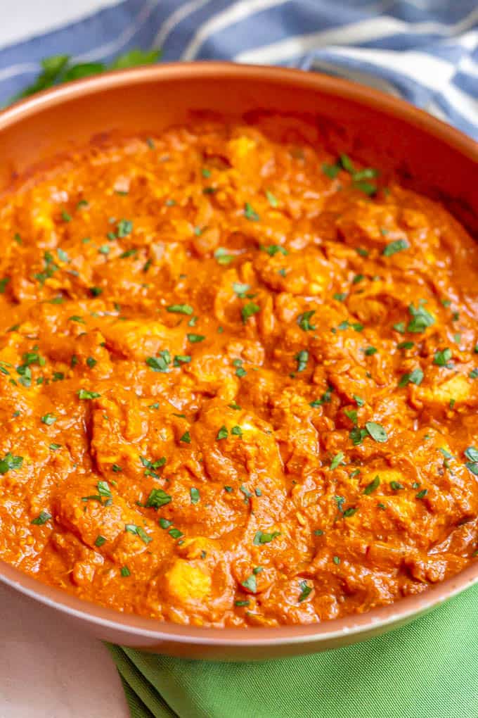 A large skillet of cooked chicken tikka masala in a creamy tomato sauce