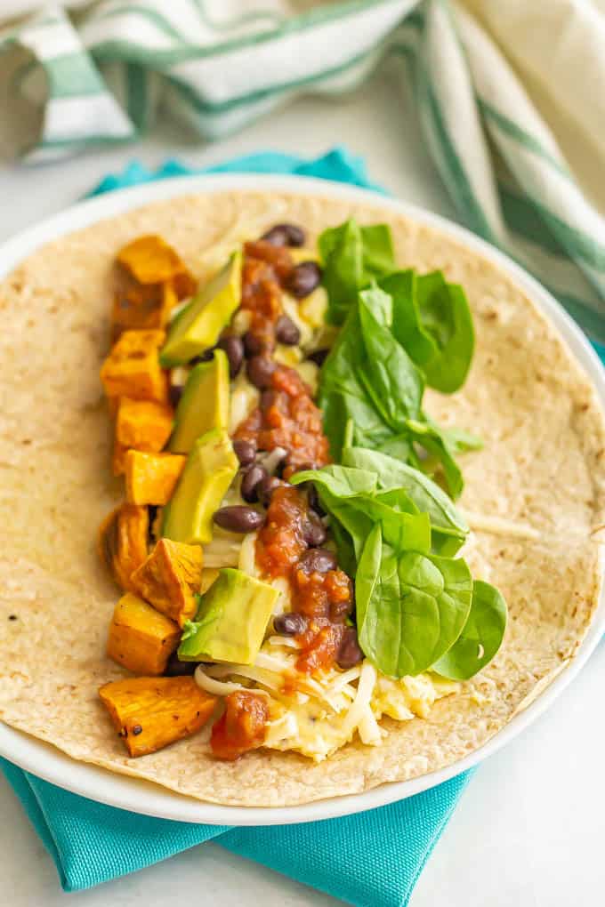 Scrambled eggs with veggies, beans, cheese and salsa in a whole wheat tortilla