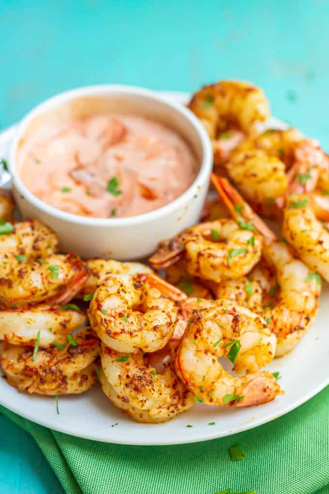 Shrimp appetizer served on a white plate with a dipping sauce