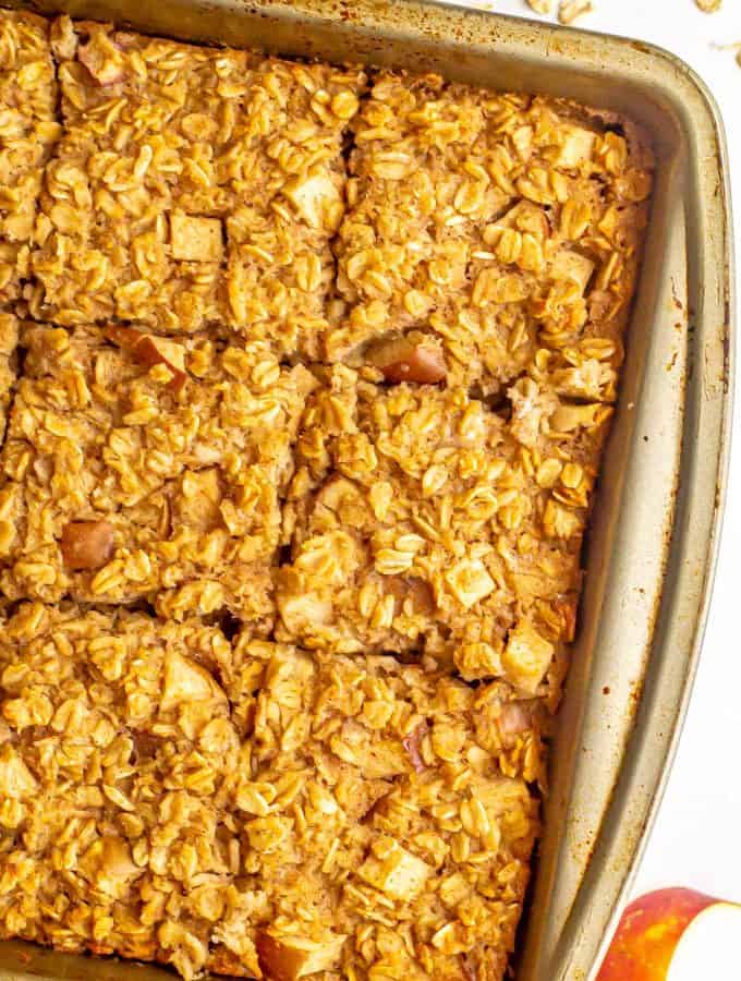 Close up of an 8x8 pan with a baked oatmeal with apple chunks cut into 9 squares.