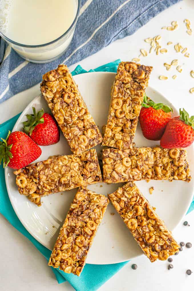 Oatmeal Cheerio breakfast bars sliced and arranged on a white plate with strawberries