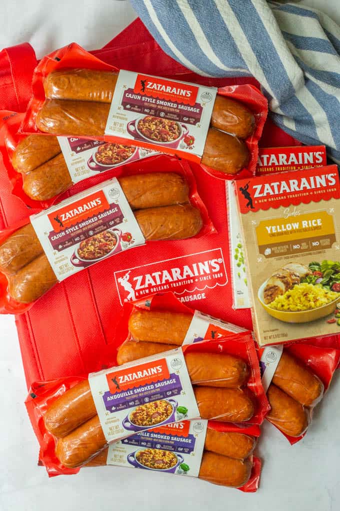 A collection of Zatarain's smoked sausages and Zatarain's yellow rice boxes spread out