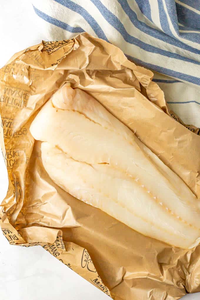 A beautiful piece of fresh, raw cod in paper wrapping