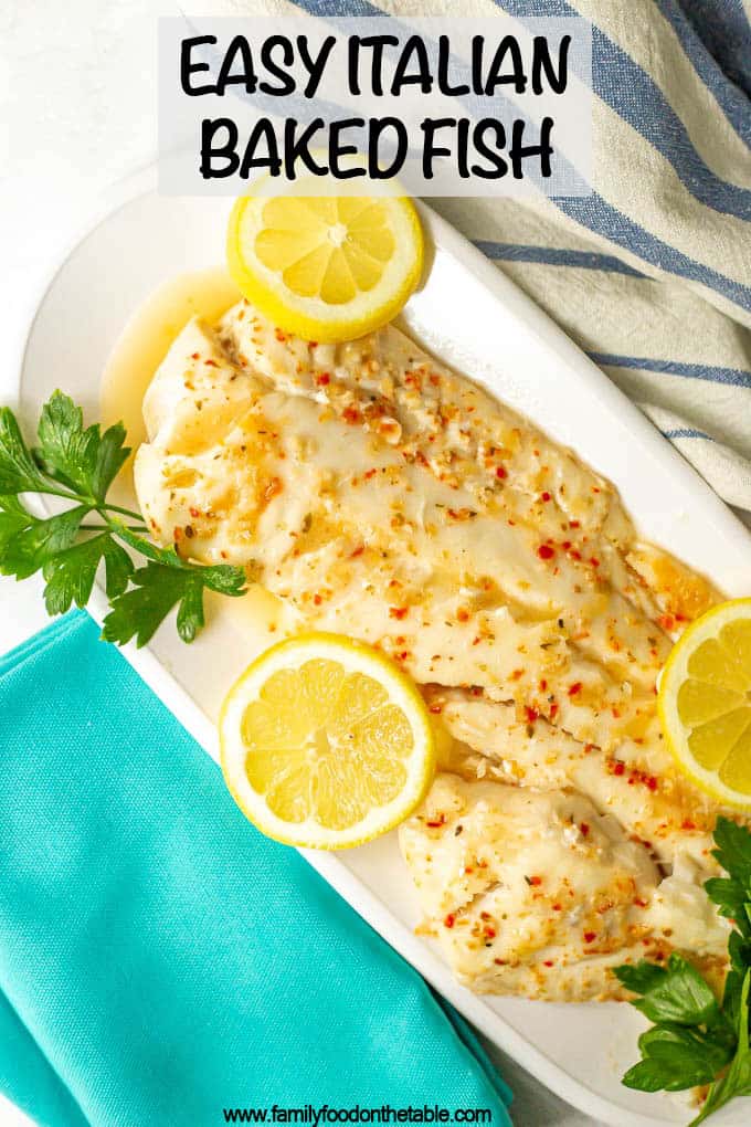 Large fish filet served with sauce on a white serving tray with lemon slices and fresh parsley as garnish and a text box on top of the photo