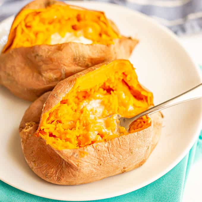 A fork getting a scoop of buttery cooked sweet potatoes