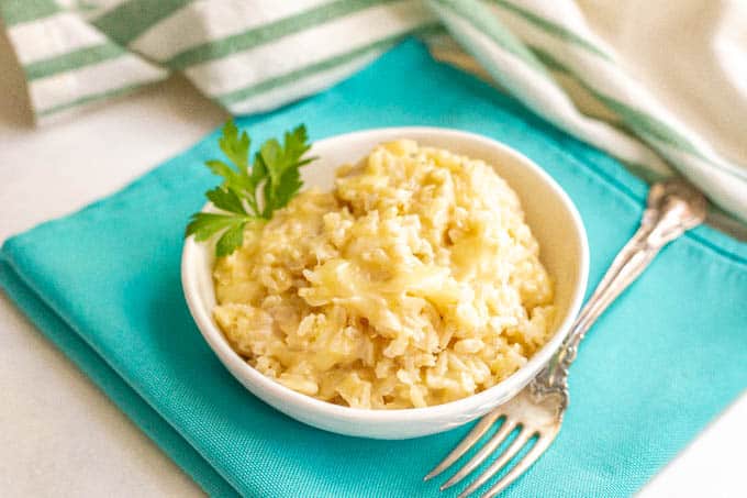 Brown rice with cheese in a small white serving bowl