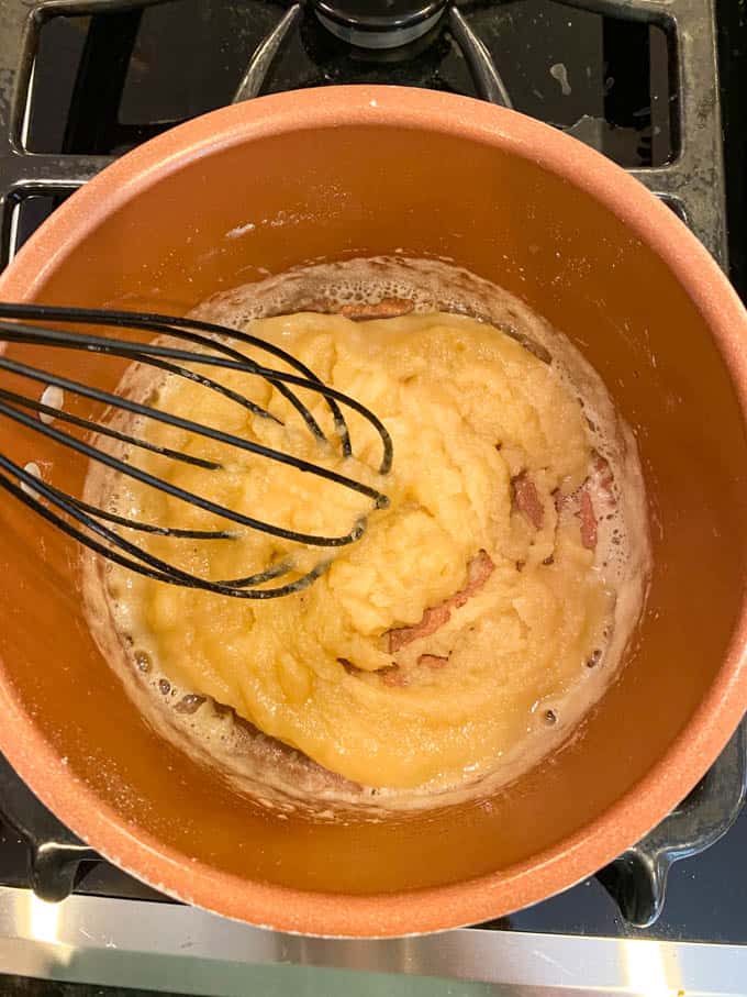A whisk incorporating turkey drippings into a roux to make turkey gravy
