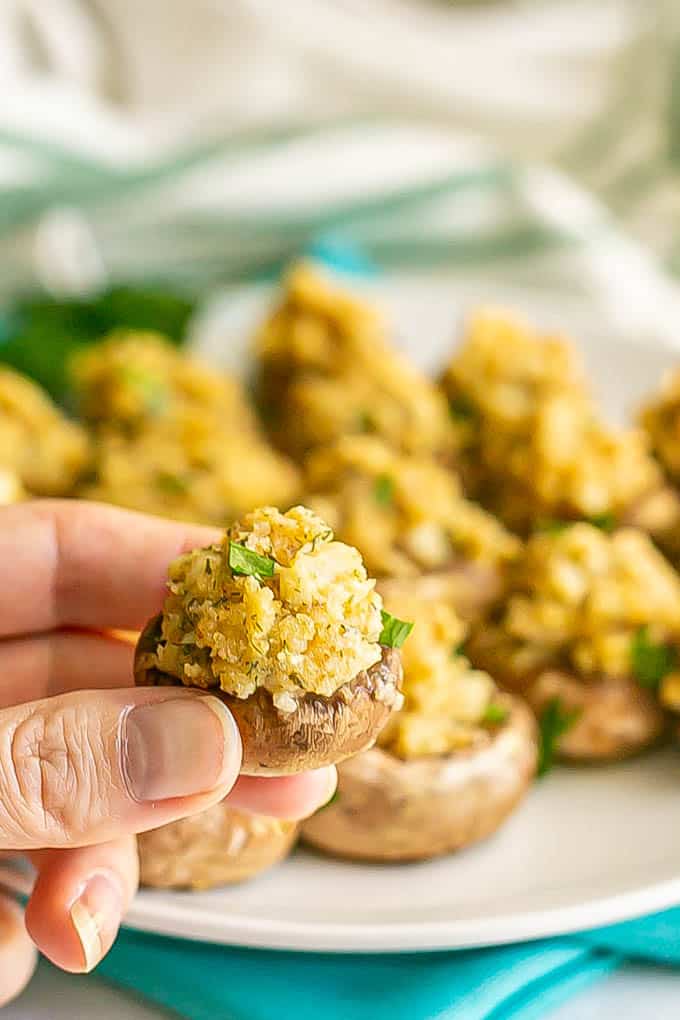 A hand holding a stuffed mushroom