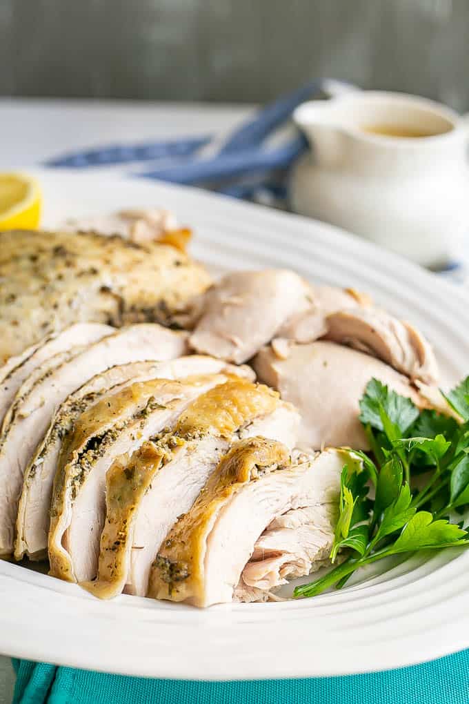 Close up of sliced skin on turkey breast served in a large white platter