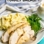 Sliced cooked turkey breast with gravy on a plate with mashed potatoes and parsley