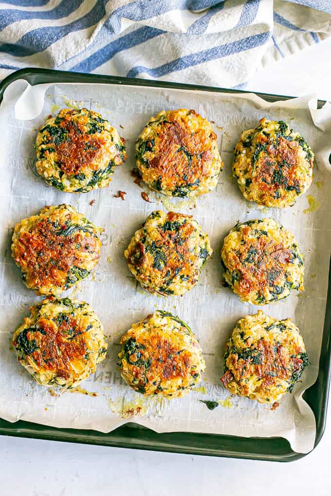 Crispy spinach cakes with cheddar and bacon on a small baking tray lined with parchment paper after baking