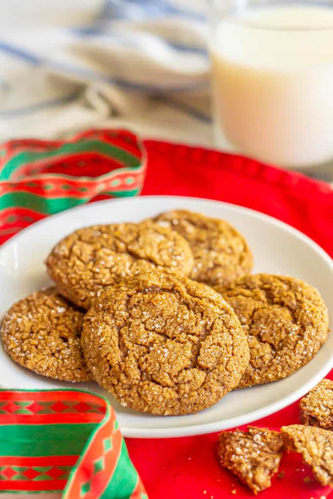 A plate of sugar sprinkled ginger snap cookies and a Christmas ribbon nearby