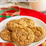 A plate of chewy ginger snap cookies with sugar on top and a Christmas ribbon nearby