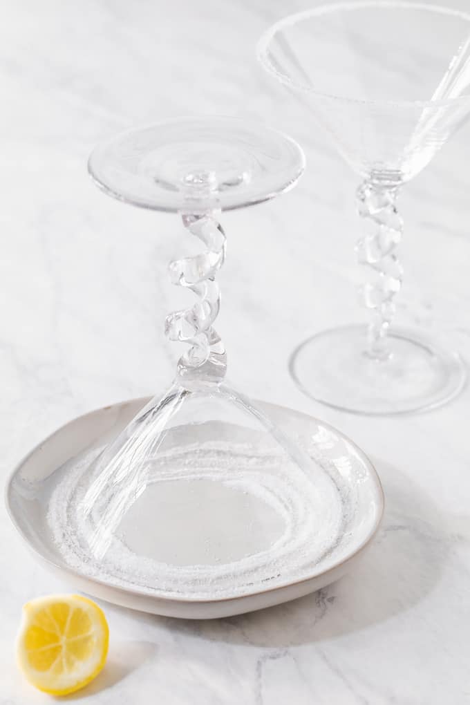 A martini glass upside down in a dish with sugar to rim the edge of the glass