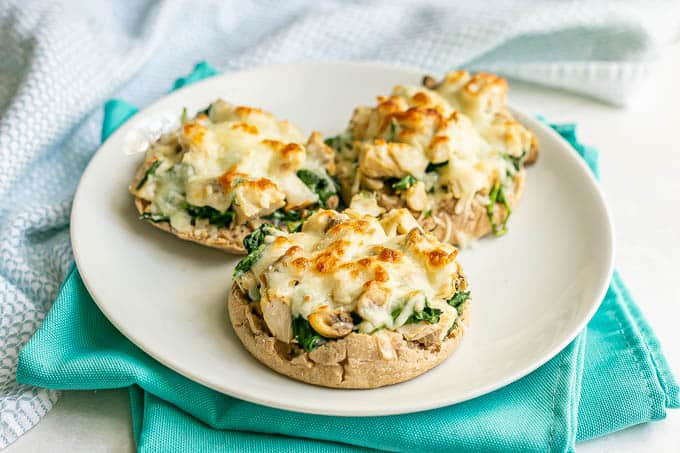 Broiled open faced turkey melts with spinach and mushrooms served on a white plate