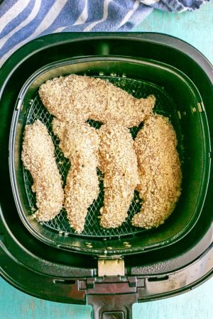 Breaded chicken tenderloin pieces in an Air Fryer tray before being cooked