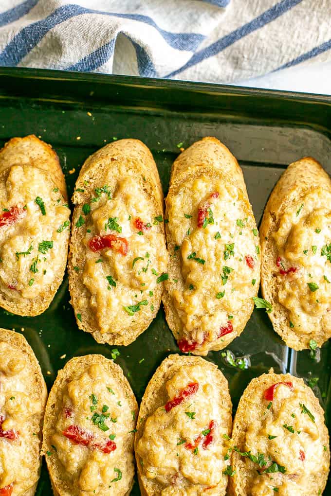 A melted crab mixture on top of toasted baguette slices after being baked