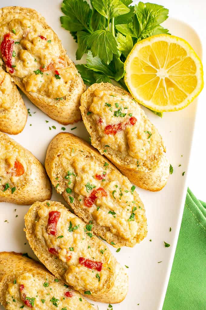 Baked crab melts on toasted bread with lemon and parsley served alongside