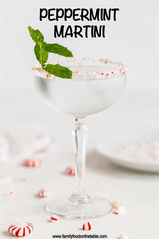 A peppermint rimmed martini glass with a peppermint martini and a sprig of mint with a text overlay on top