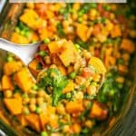 A scoop of vegetarian curry being lifted out of a slow cooker with a text box overlay on the photo