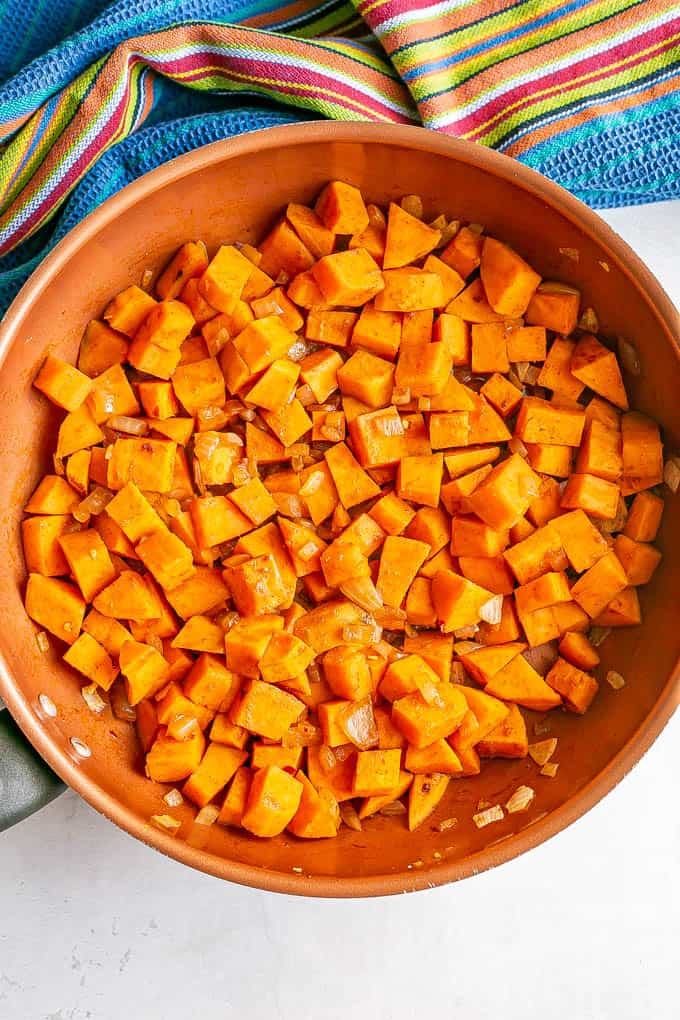 Sweet potatoes cooking in a copper skillet