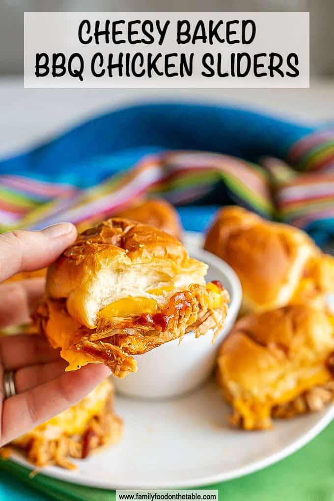 A hand holding up a cheesy BBQ chicken slider roll with a text overlay on the photo