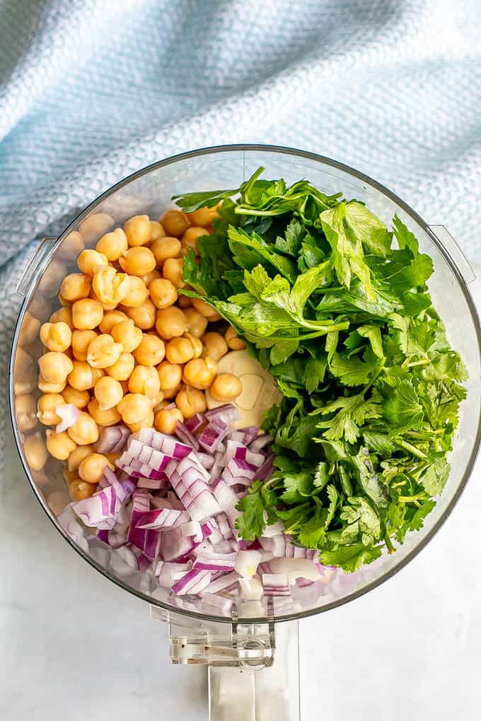 Chickpeas, fresh herbs and red onion in a food processor before being broken down