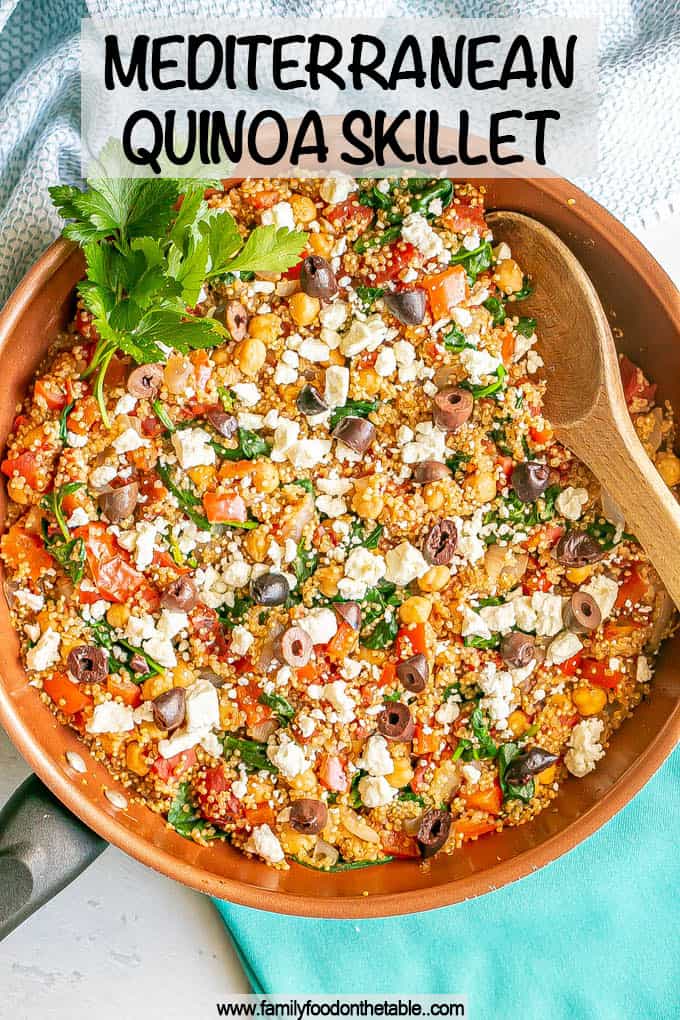 Quinoa and chickpea mix in a copper skillet with tomatoes and spinach with feta cheese and olives on top and a text overlay on the photo