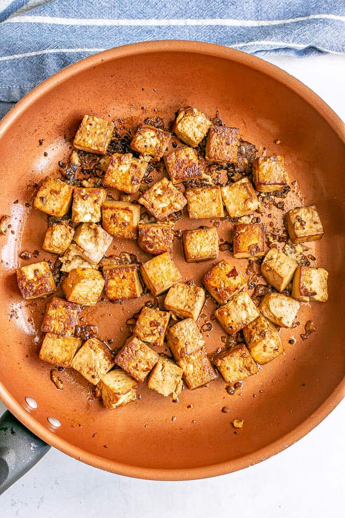 Crispy browned cubed tofu in a copper skillet