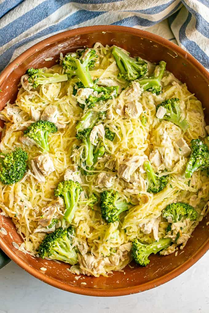 A large copper skillet with spaghetti squash mixed with chicken and broccoli