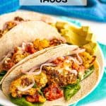 A trio of vegan cauliflower tacos in soft tortilla wraps on a white plate with spinach, salsa and red onions for toppings and a text overlay on the photo
