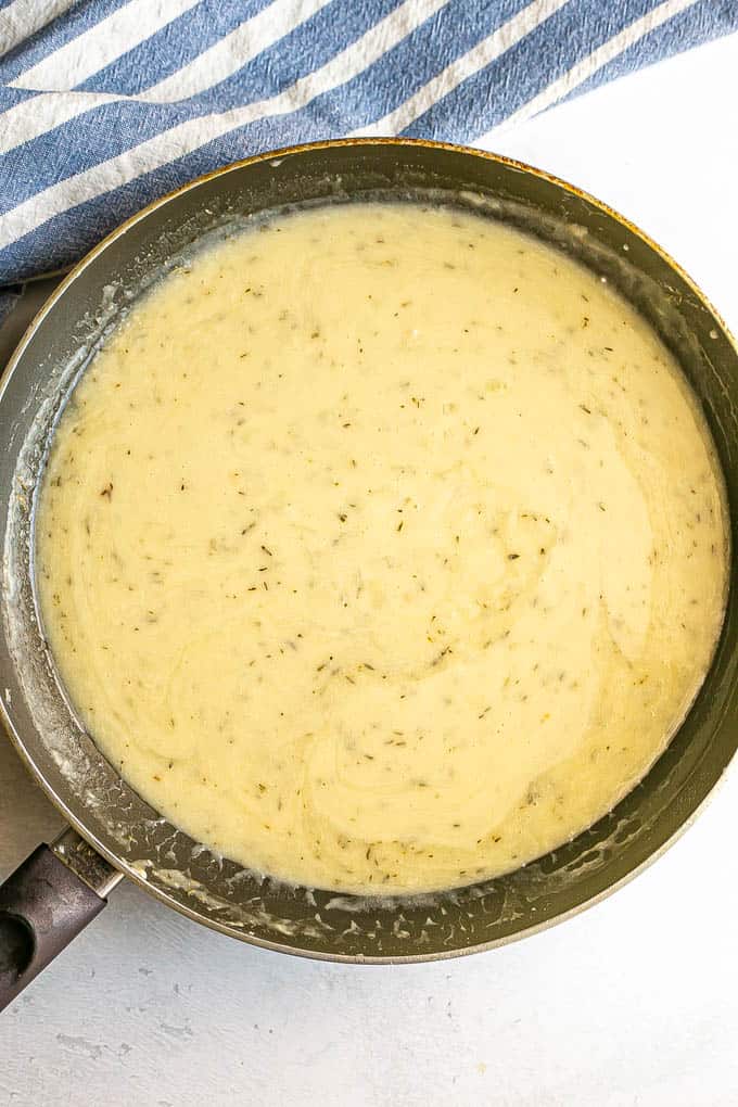 A creamy white sauce in a large skillet