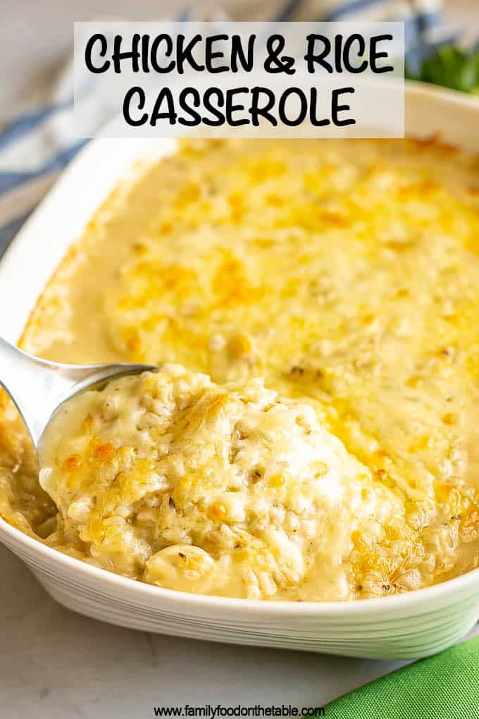 A metal spoon scooping up some chicken and rice casserole from a large white baking dish with a text overlay on the photo