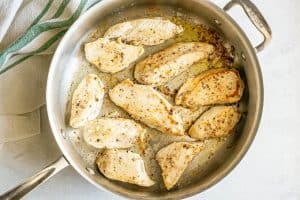 Browned and seared chicken strips in a large all-clad skillet