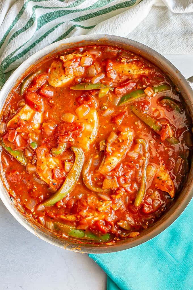 Chicken cacciatore with peppers in a tomato sauce in a large skillet after cooking