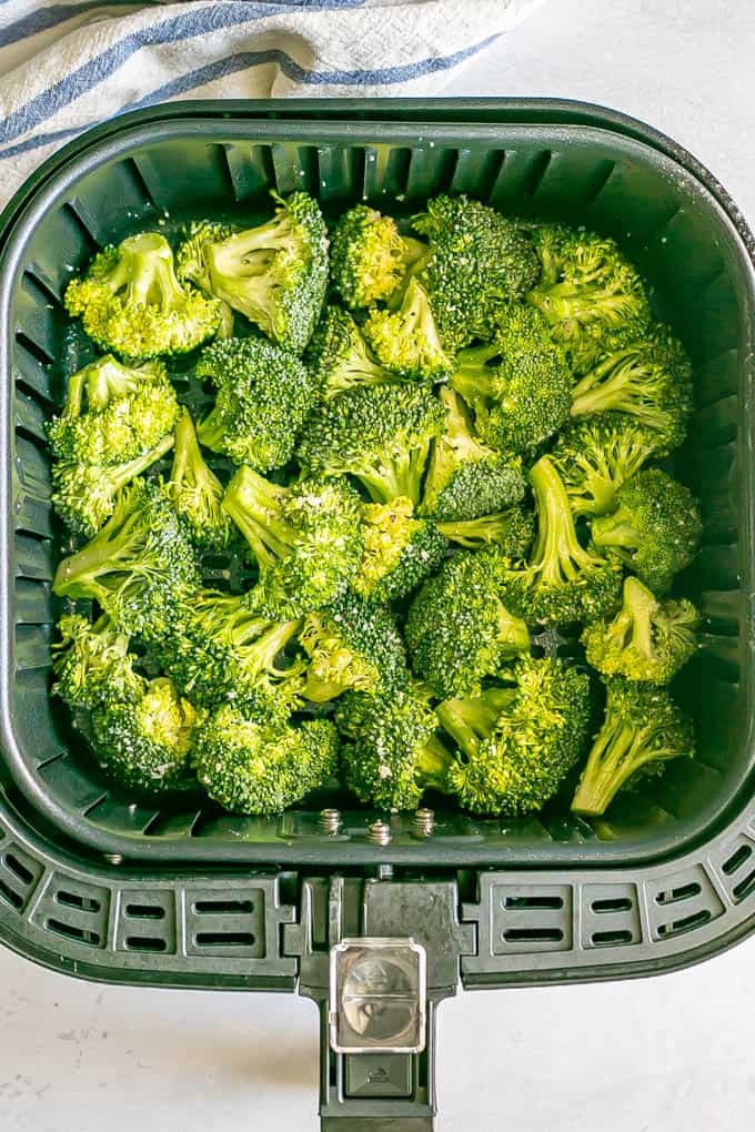 Seasoned broccoli florets in an Air Fryer tray before being cooked