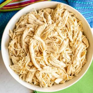 Overhead shot of shredded chicken in a large white bowl