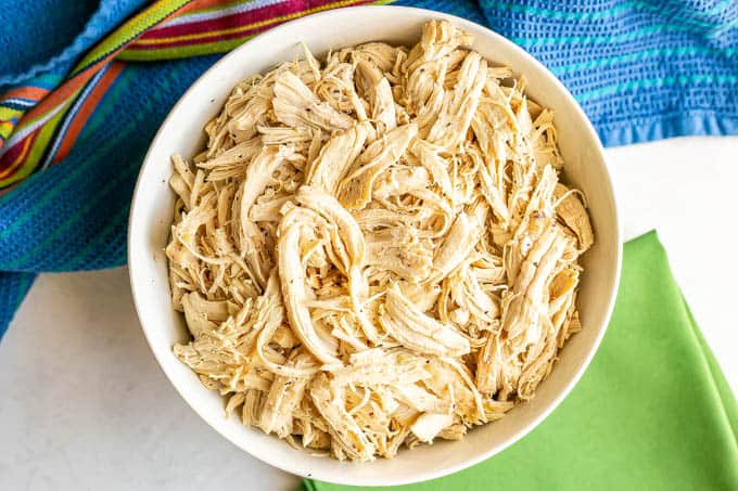 Overhead shot of shredded chicken in a large white bowl