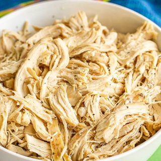Shredded cooked chicken served in a large white bowl