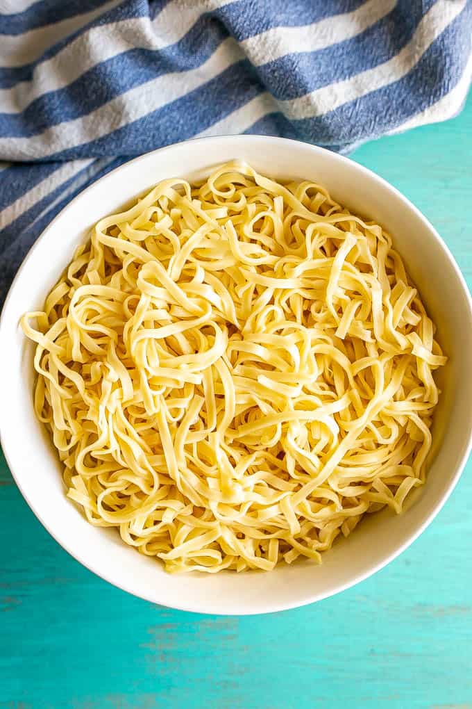 A white bowl full of cooked Chinese egg noodles