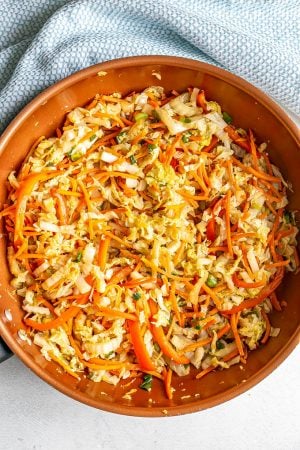 A copper skillet with sauteed cabbage, carrots and veggies