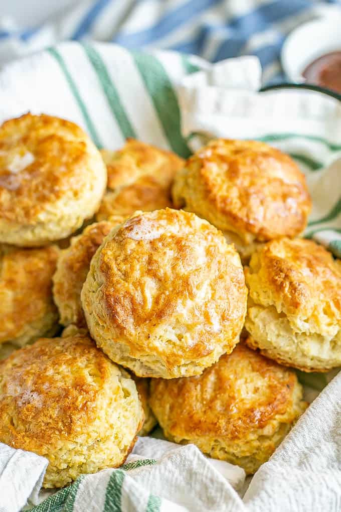 A napkin lined basket with fluffy, browned and buttery homemade biscuits
