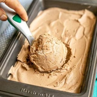 A scoop of homemade chocolate ice cream being taken from a small pan