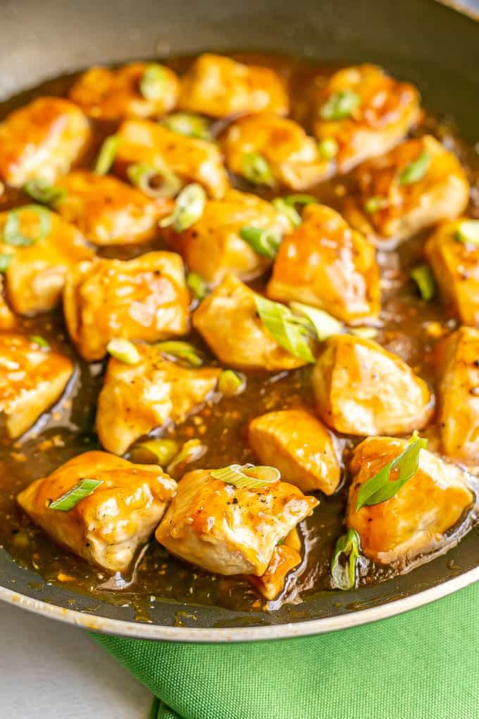 Cubed chicken pieces cooking in teriyaki sauce in a large skillet