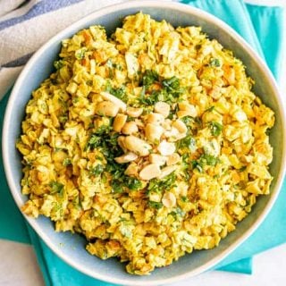 Overhead horizontal photo of curried coleslaw served with extra chopped peanuts and cilantro on top