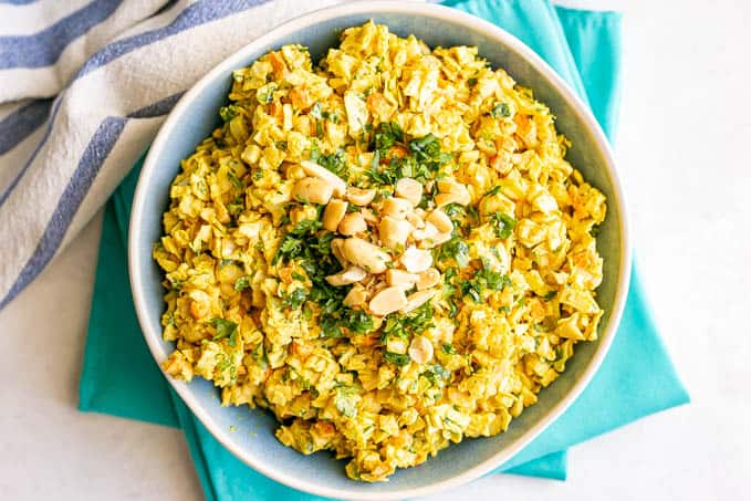 Overhead horizontal photo of curried coleslaw served with extra chopped peanuts and cilantro on top