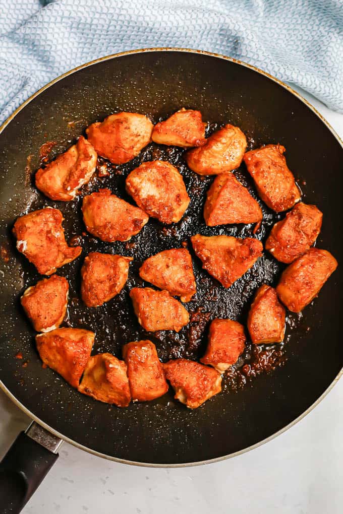 Crispy browned chicken pieces after being cooked and seared in a large skillet