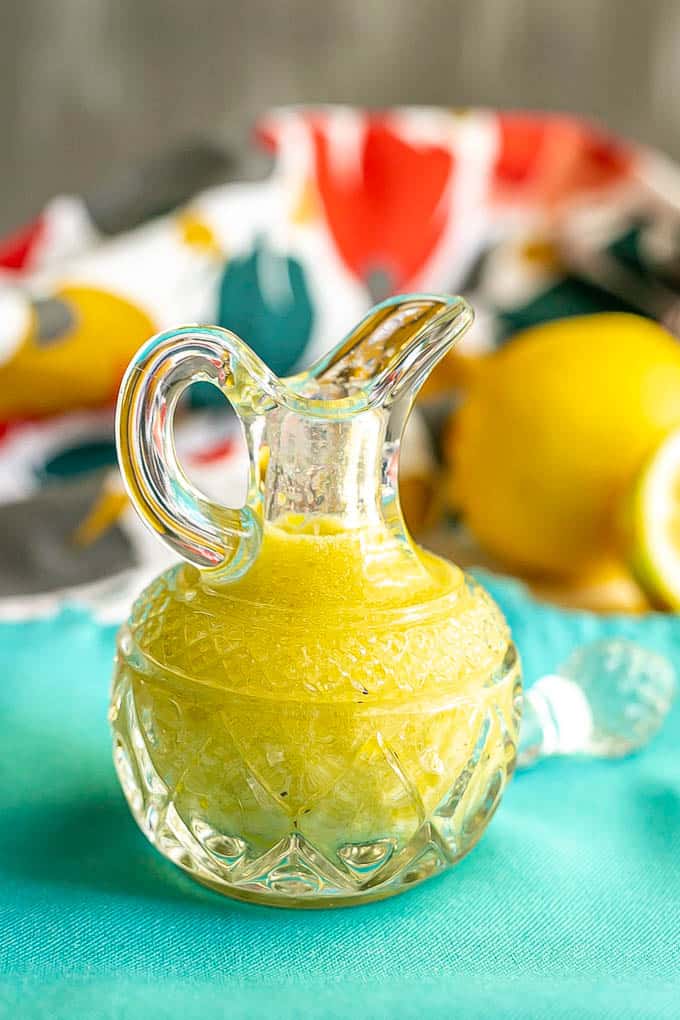 A yellow lemon vinaigrette in a small glass crystal jar