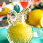 A yellow lemon vinaigrette in a small glass crystal jar with a text overlay on the photo